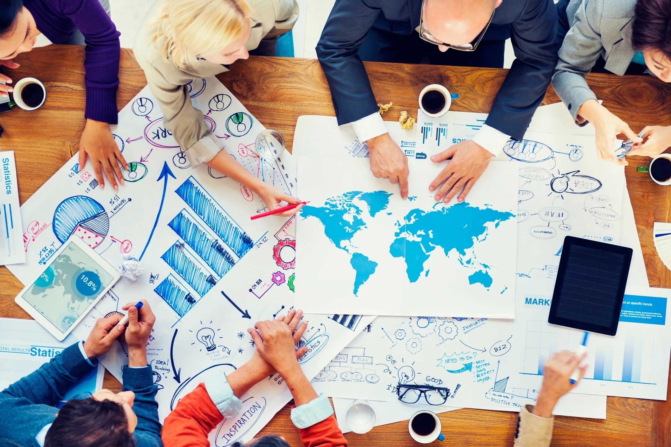 A group of people sitting around a table with papers.